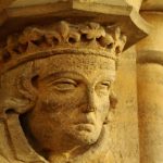 Carved medieval stone head set into the church wall.