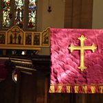 Altar with purple frontal and gold cross in the church sanctuary.